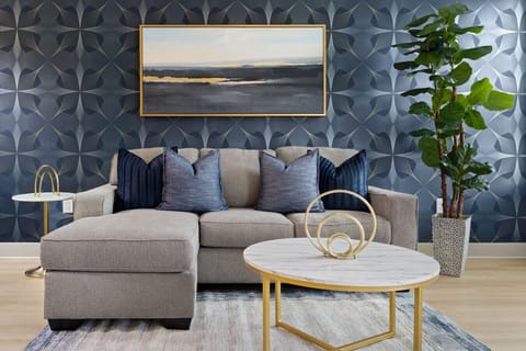Stylish Living Room-Modern sofa with chic throw pillows, elegant artwork, and a marble coffee table. Bright space with natural light and greenery, perfect for relaxing in comfort and style.