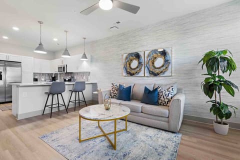 Chic Living & Kitchen Area-Kick back and relax in this stylish, open-concept space. The living area, with its comfy sofa and artistic decor, flows right into a modern kitchen, perfect for a quiet night in or entertaining guests.