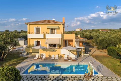 Villa Exterior with Private Pool and Sun Loungers – Aerial view of the villa surrounded by greenery, showcasing the spacious pool terrace.