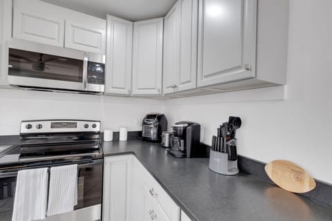 The kitchen is a chef's dream, combining modern design with all the essentials for a comfortable stay. It features a full suite of high-quality stainless steel appliances, including a refrigerator, cooktop, and oven, making meal preparation a breeze.