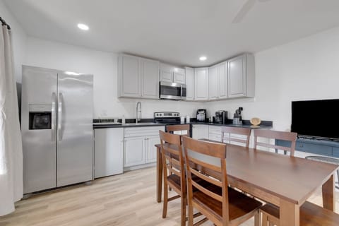 Adjacent to the living area is a dining table, ideal for enjoying meals with family and friends. Whether you're having a casual breakfast, a home-cooked dinner, or planning a game night, the dining space offers both convenience and charm. 