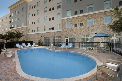 Dive into sunlit relaxation beside the sparkling outdoor pool.