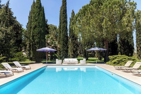The beautiful pool at Villa Specchia is surrounded by mature trees. 