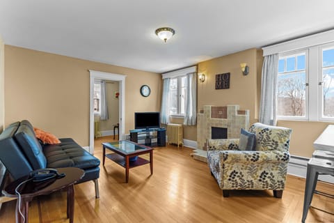 Inviting Sun-Filled Living Room. Relax in this bright lounge featuring hardwood floors, a decorative fireplace, and plush seating—the perfect hub for your stay.