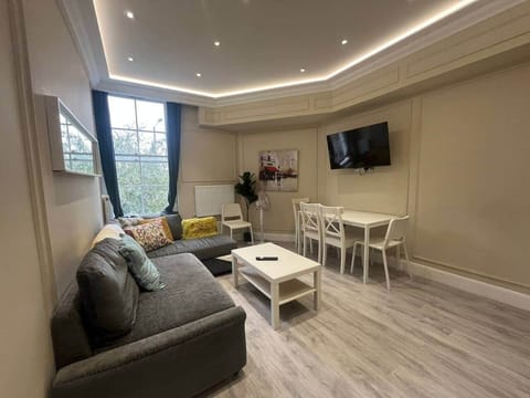 Living room open plan featuring large sofa, with spare sheet if wanted to be used as bed. Dining table and coffee table.