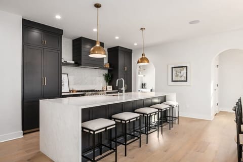 Custom built kitchen with waterfall countertops and barstool seating