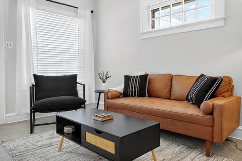 Stylish and cozy living room with a modern sofa, soft lighting, & natural light