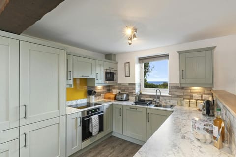 Kitchen with wall and base units. Window with a view towards the sea