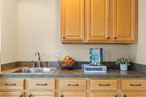 Snack and beverage bar with sink, mini fridge, and family game setup