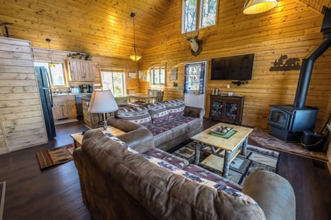 Great room open concept with large screen TV and wood burning stove. 