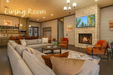 Spacious open-concept living area with fireplace, TV and fully equipped kitchen