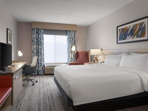 Relax in a spacious, sunlit room with a plush bed.