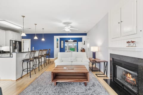 Relax in the bright, coastal-inspired living room where large windows frame stunning water views.