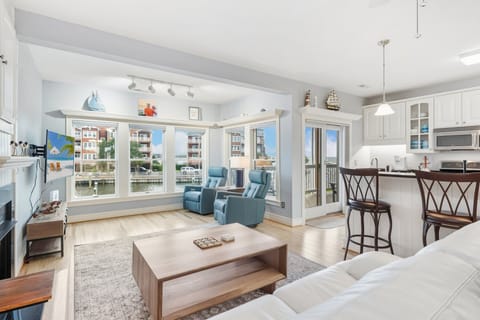 Relax in the bright, coastal-inspired living room where large windows frame stunning water views.