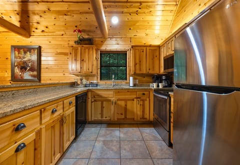 Fully stocked kitchen with modern appliances and woodsy charm.