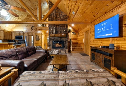Relax on the sectional couch by the fireplace—perfect cabin vibes.