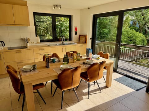 Sunny kitchen with dining table, full amenities, and doors to the balcony
