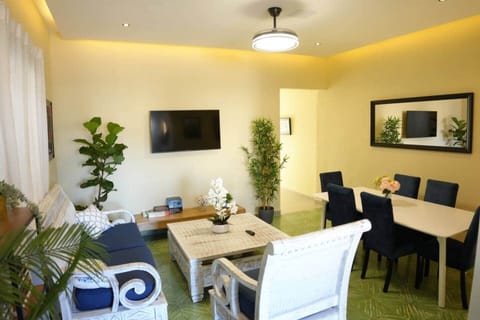 Cozy tropical-modern space with comfy seating, dining for six, stylish decor, lush plants, and warm lighting—perfect for relaxing after exploring the Colonial Zone.