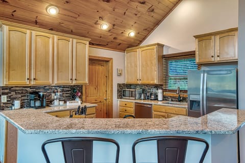 Fully equipped kitchen with stainless steel appliances and a breakfast bar.