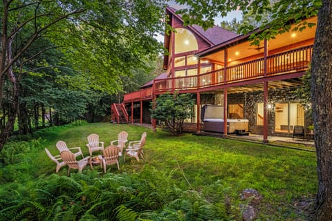 Spacious backyard with lush greenery, a cozy fire pit, and a relaxing hot tub.