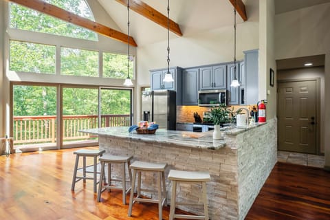 Spacious kitchen with large side windows offering serene outdoor views — perfect for cooking and gathering.