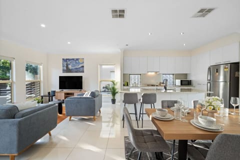 Experience effortless flow in the open-plan design, where the living, dining, and kitchen areas connect seamlessly to create a light-filled, welcoming atmosphere.