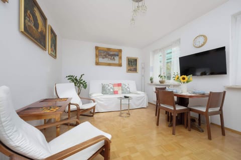 The bright living room with a comfortable armchair and a large TV creates a pleasant spot to unwind after a busy day.