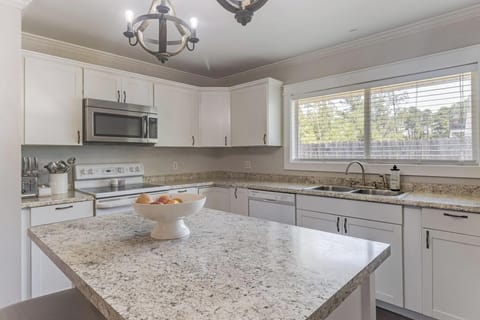 Modern kitchen with granite countertops, stainless steel appliances, and a sunny windowed sink.