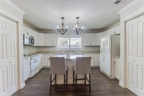 Fully equipped kitchen with modern appliances and adjacent dining space for easy group meals.