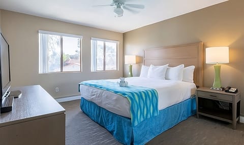 Unwind in a sunlit king bed with crisp linens.