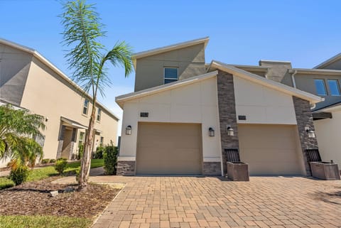 Step into a charming exterior featuring a stone-accented facade and a welcoming driveway lined with palm trees. The ample natural light and clean lines create an inviting first impression, setting the tone for a delightful stay.