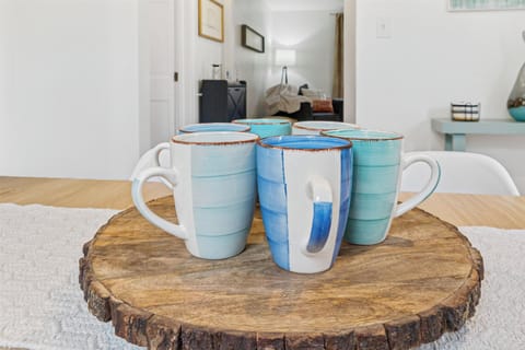 Classy cups circle the lazy Susan in our South Bend dining room, flanked by coasters and a peek at your favorite reading nook—perfect for sipping, gathering, and unwinding near Notre Dame.