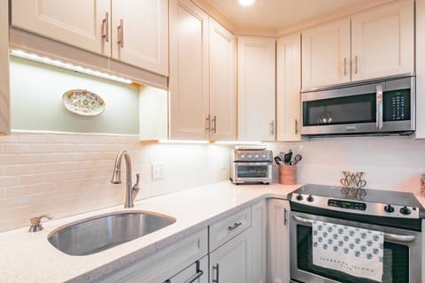 The corian counters, tiled backsplash and undercabinet lighting create a welcoming kitchen.
