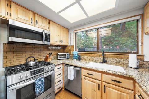Sun-filled kitchen with skylight and stainless steel appliances.