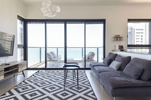 Bright living room opens to balcony views, creating an inviting space to relax after beach walks.