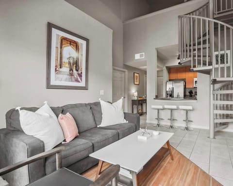Living room in the second apartment with sleeper sofa and spiral staircase