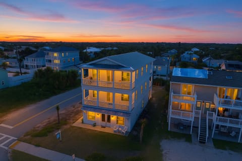 Elegant beachside home lit at dusk, ready for unforgettable group escapes.