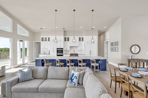 Living, dining and kitchen area with kitchen island and stools