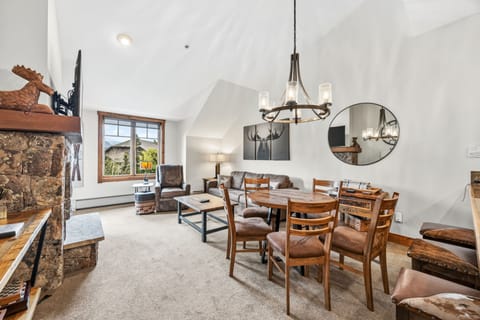 Vaulted great room with moose canvas, dining, and kitchen.