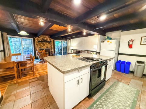 The kitchen has a large island with a built in oven and stove. 