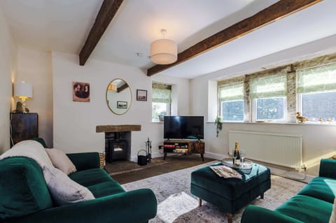 Relax in this stylish living room in the heart of Haworth. With rustic beams, velvet sofas, and a smart TV, it’s the perfect mix of charm and comfort. Large windows offer lovely views, filling the space with light and showcasing the fabulous views.