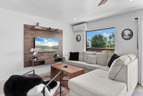 Bright living area with modern seating and corner windows overlooking the city