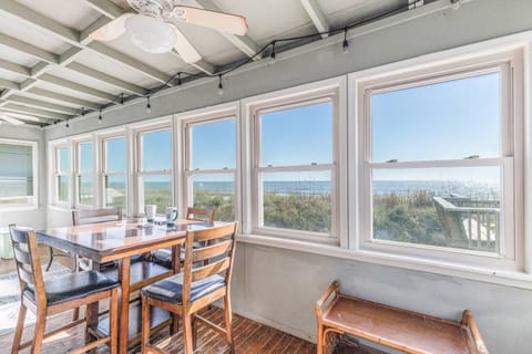 Ocean front home with sun room and an additional table, perfect for enjoying morning coffee or relaxing evenings with beach views.