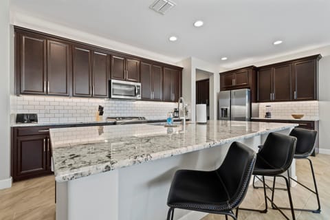 The large kitchen island features bar seating for three, providing additional dining space—perfect for casual meals, morning coffee, or chatting while cooking.