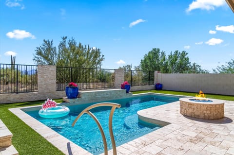 Resort-style backyard with sparkling pool, cozy firepit, and desert views—perfect for sunny days and starry nights.