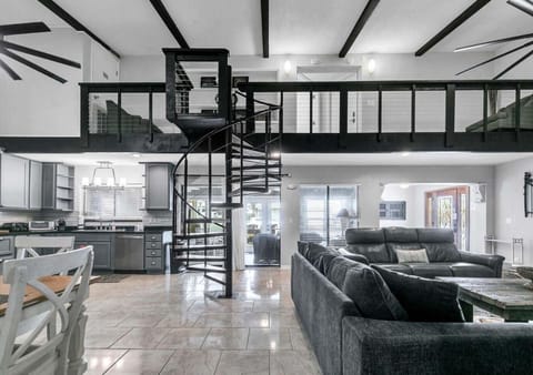 Spacious living room with modern spiral staircase and loft view