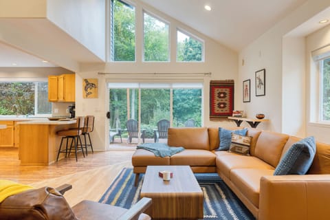 Bright living room with vaulted ceilings and large windows.
