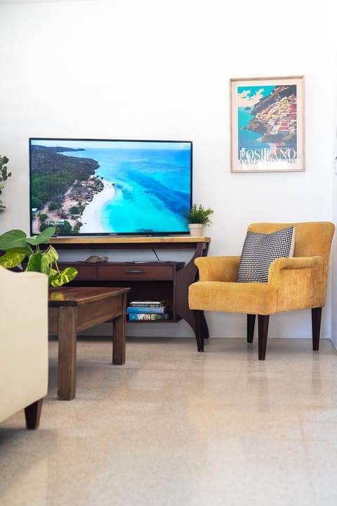 Bright living room with comfy seating and smart TV for relaxing stays.
