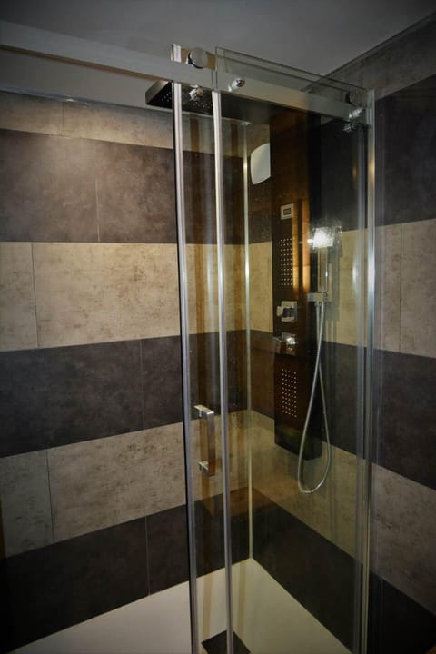 La large douche et ses parois en verre