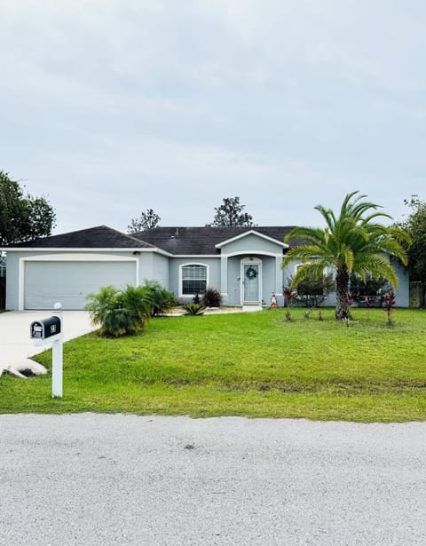 Charming coastal home with private driveway and tropical landscaping.